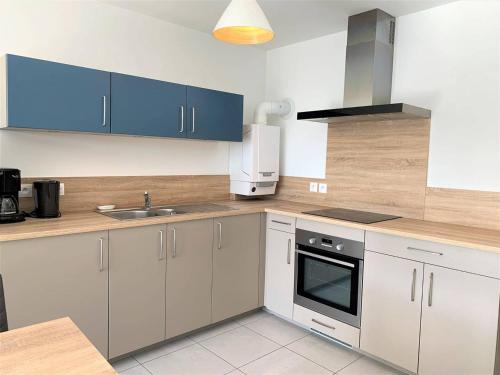 eine Küche mit weißen und blauen Schränken und einem Waschbecken in der Unterkunft Appartement Quiberon, 2 pièces, 2 personnes - FR-1-478-162 in Quiberon