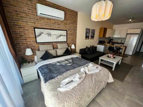a bedroom with a bed and a brick wall at Sophia Pool Apartments in Caesar Blue Resort including Breakfast till 4pm, Gym, 5 Swimming Pools, Sauna, Hammam, Kids' club available in Perivolia tou Trikomou
