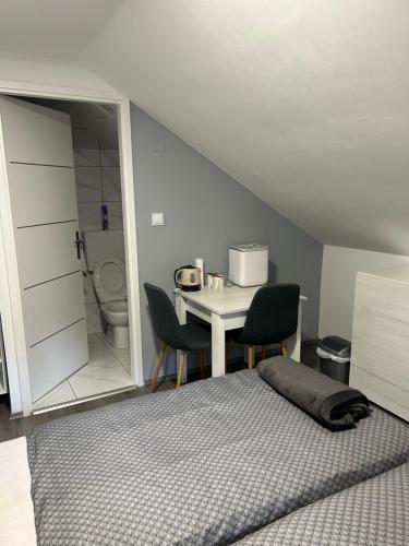 a bedroom with a bed and a table and a toilet at Sobe “Stari Grad-Samobor” in Samobor