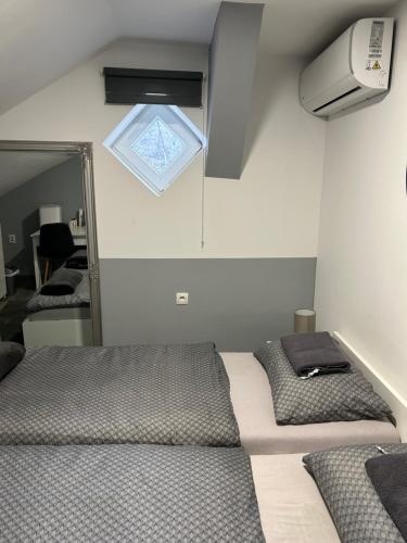 a bedroom with two beds and a mirror at Sobe “Stari Grad-Samobor” in Samobor