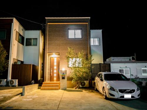 um carro estacionado em frente a uma casa à noite em Ocean Front Maezato em Ishigaki
