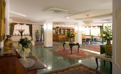 a lobby with a living room with tables and chairs at Valdenza Hotel in Campegine