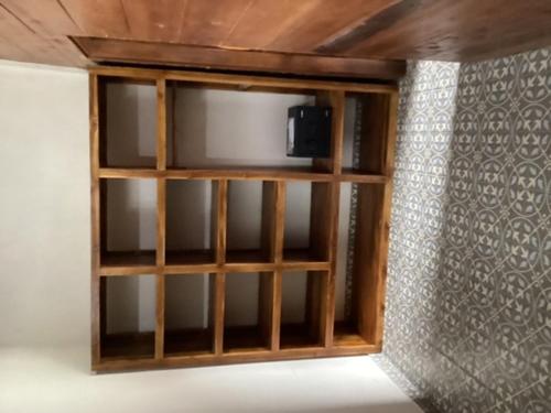 a wooden shelf with a tv on a wall at THE JINENG,S SANUR in Sanur