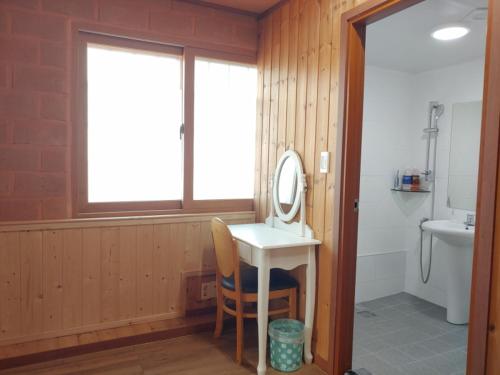 a bathroom with a sink and a mirror at Jeju Hanibaram Pension in Jeju