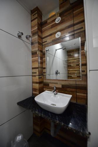 uma casa de banho com um lavatório e um espelho em Hotel Surya Lodge em Mysore