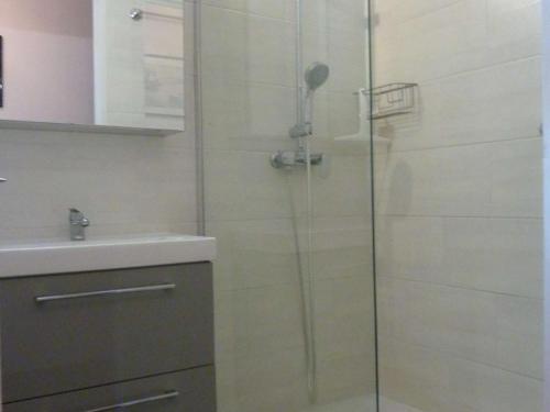 une douche avec une porte vitrée à côté d'un lavabo dans l'établissement Appartement rénové 4 pers. proche plage, calme, parking, animaux acceptés - FR-1-387-131, à Marseillan