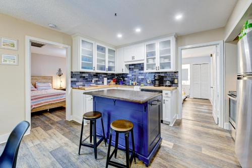 a kitchen with white cabinets and a blue island with stools at Golf Villa Getaway in Harrington