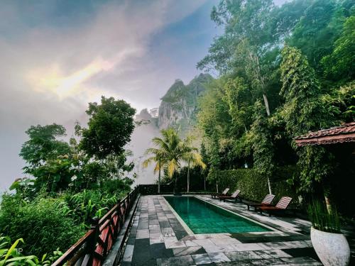 a swimming pool in a resort with mountains in the background at Villa Borobudur Resort in Borobudur