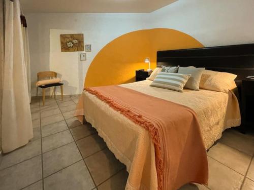 1 dormitorio con 1 cama grande y 1 silla en *NUEVO oasis privado* 2 dormitorios-cochera en Godoy Cruz