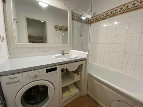 une salle de bain avec une machine à laver et un lavabo dans l'établissement Appartement 2 pièces cabine, piscine, tennis et parking sécurisé aux Issambres - FR-1-226-477, à Roquebrune-sur Argens