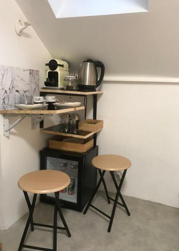 deux tables et tabourets dans une cuisine avec un comptoir dans l'établissement Chambre - Bed & Breakfast - Plage 50m - Résidence, à Saint-Malo