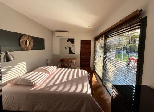 une chambre avec un lit et une grande fenêtre dans l'établissement VILLA AXEL, à Marseille