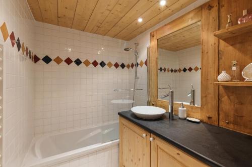 Appt Bec A2 - Happy Rentals في Le Tour: حمام مع حوض وحوض استحمام