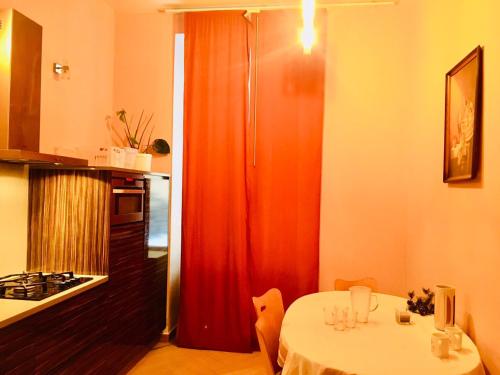 a kitchen with a table and a red curtain at Hotel Room in Praha 2 Square in Prague