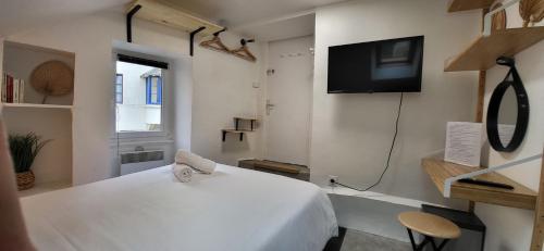 sypialnia z białym łóżkiem i telewizorem z płaskim ekranem w obiekcie Chambre - Bed & Breakfast - Plage 50m - Résidence w Saint-Malo
