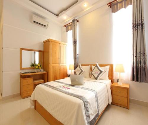 een slaapkamer met een bed met een laptop erop bij Yen Nam Hotel Nguyen Trong Tuyen in Ho Chi Minh-stad