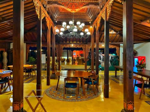 a dining room with a table and chairs and a chandelier at Villa Borobudur Resort in Borobudur