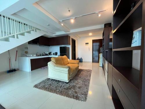 a living room with a couch and a kitchen at Neo Soho Apartment / Office near Central Park Mall in Jakarta