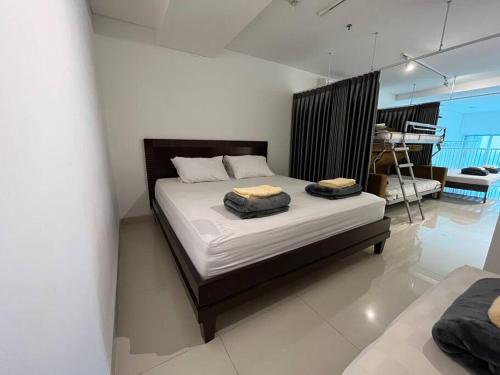 een slaapkamer met een bed met 2 kussens erop bij Neo Soho Apartment / Office near Central Park Mall in Jakarta