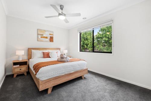 1 dormitorio con cama y ventana en Summer Breeze - 10 mins to Barwon Heads & Torquay!, en Mount Duneed