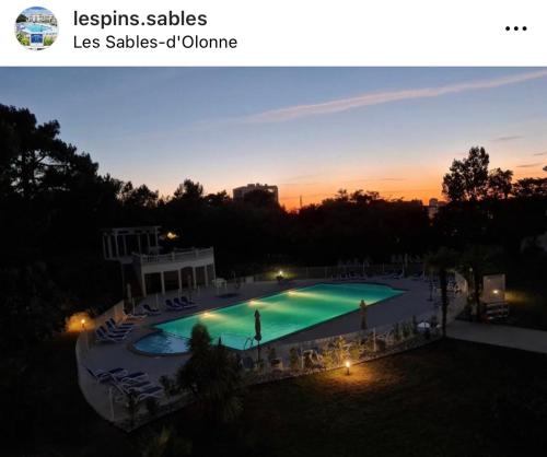 a view of a swimming pool at sunset at Les Pins - 3 pièces - Vue sur piscine - 600m mer - Les Sables d'Olonne in Les Sables-dʼOlonne