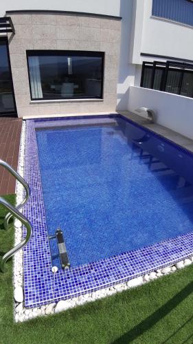 a large blue swimming pool in a house at Casa do Golfe by VinteOito in Amarante