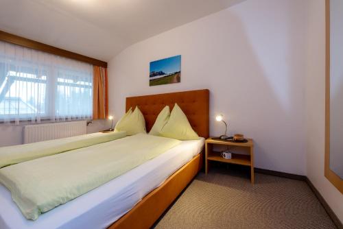 a hotel room with a large bed and a window at Energiepension Schwaiger in Leogang