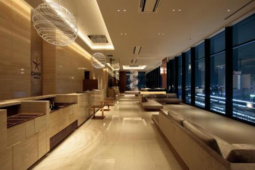 a lobby of a hotel with couches and windows at Candeo Hotel Utsunomiya in Utsunomiya