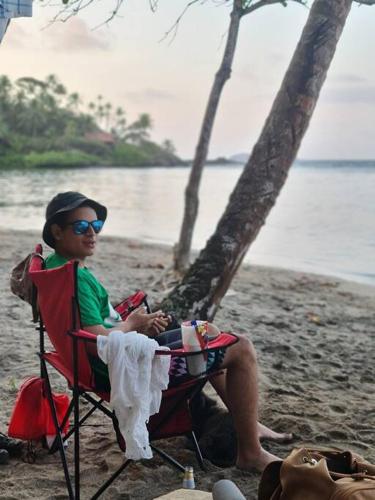a man sitting in a chair on a beach at Casa-cabaña Jefe Indio /Playa Cacique in Cacique