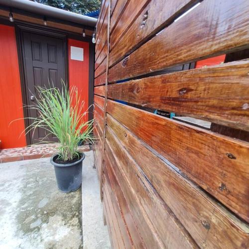 a wooden fence with a potted plant next to a door at Casa-cabaña Jefe Indio /Playa Cacique in Cacique