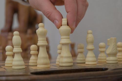 a person playing chess on a chessboard at Armenia in Nerkʼin Giratʼagh