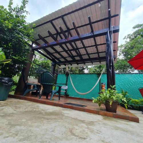 a pergola with a table and a bench and a swing at Casa-cabaña Jefe Indio /Playa Cacique in Cacique