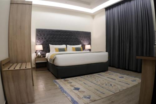 a bedroom with a large bed with a large headboard at RAWND Hotel Apartments in Dammam