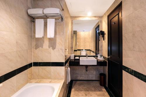 W łazience znajduje się wanna, umywalka i lustro. w obiekcie AP Premier Batam w mieście Nagoja