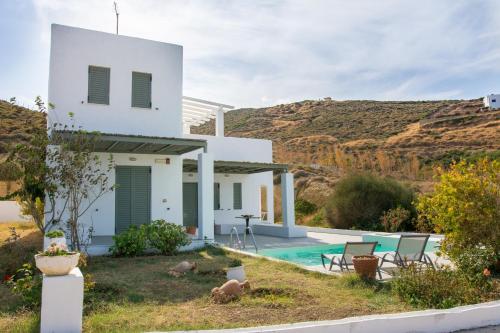 uma casa branca com piscina e montanhas ao fundo em Superior Villa Lino em Skiros