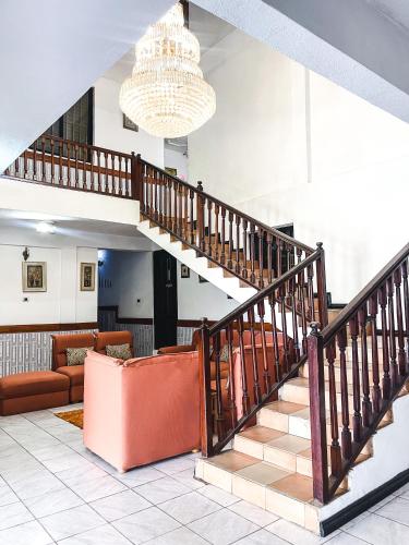 a living room with a staircase and a couch at Hill View Hotel McCarthy Hills in Bortianor