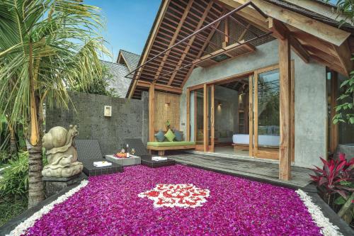 a house with a large carpet of purple flowers at Wana Bucu Villas by GenuineHost in Ubud