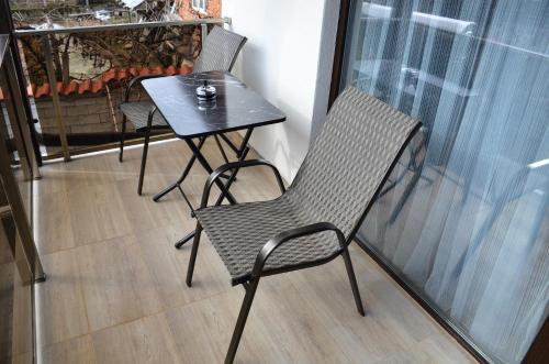 two chairs and a table on a balcony at Bóris House in Ognyanovo