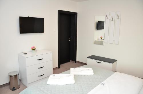 sypialnia z łóżkiem, komodą i telewizorem w obiekcie Bóris House w mieście Ognianowo