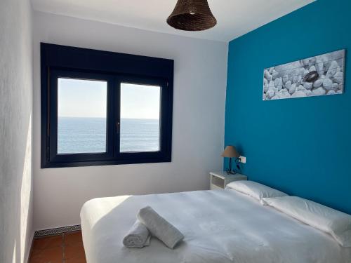 a bedroom with a bed with blue walls and a window at Vistaazul in Las Negras