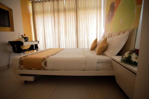 a bedroom with a large bed with a window at Millennium Continental in Cochin