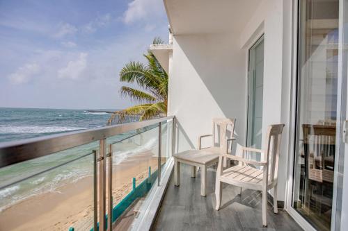a balcony with two chairs and a view of the beach at Hikkaduwa Beach Hotel - Special Deal on 3 Night or More Stays in Hikkaduwa