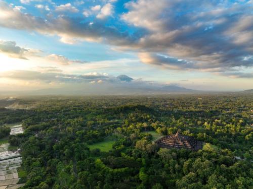 an aerial view of a city with trees and clouds at Villa Borobudur Resort in Borobudur