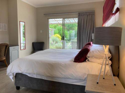 a bedroom with a large bed and a window at Maroela House Guest Accommodation in Bellville