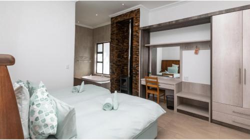 ein Schlafzimmer mit einem Bett und einem Schreibtisch in einem Zimmer in der Unterkunft Sandune Game Lodge in Gobabis