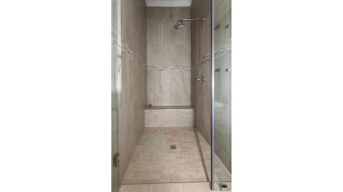 a bathroom with a shower and a glass door at Sandune Game Lodge in Gobabis