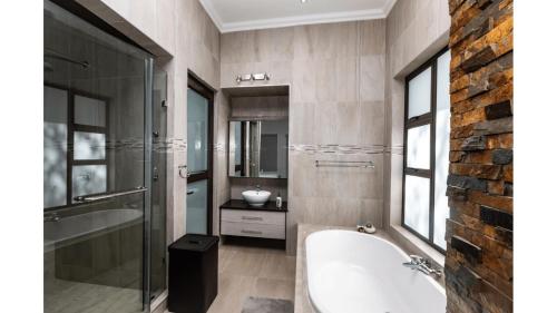 uma casa de banho com uma banheira e um lavatório em Sandune Game Lodge em Gobabis