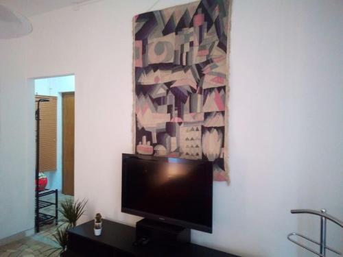 a flat screen tv on a wall with a painting at C&C - Cozy and Cute in Milan