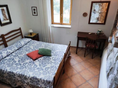 um quarto com uma cama, uma mesa e uma secretária em A casa di Peppino Villa Greco em Tindari