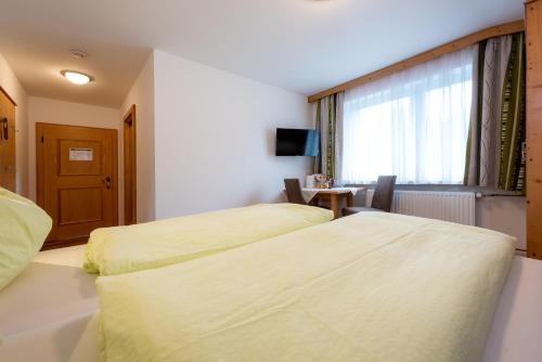 a hotel room with two beds and a window at Energiepension Schwaiger in Leogang